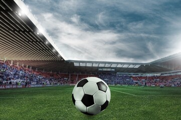 Classic football ball on big stadium