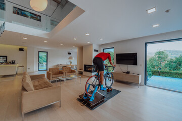 A man riding a triathlon bike on a machine simulation in a modern living room. Training during...