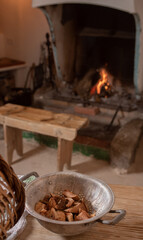 colander with sliced mushrooms, rustic cooker with fire in the background burning