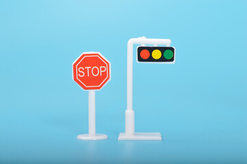 Traffic light toy and stop sign isolated on a blue background.