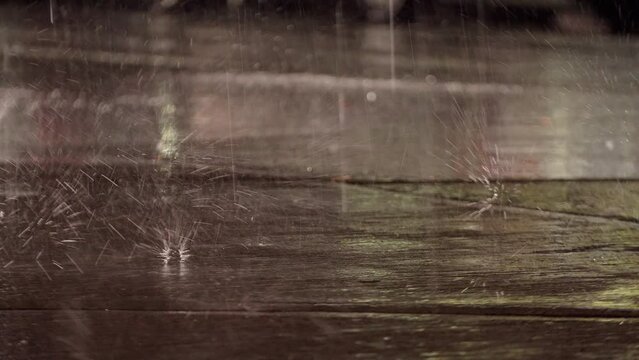 Road and big heavy raindrops falling on the aspalt with splash. Hailstones are bumping at asphalt at night, wet ccld autumn weather. 