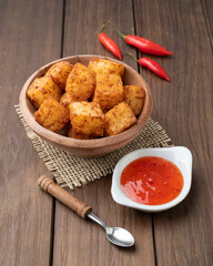 Tapioca dice, typical northeast brazilian food with chilli pepper syrup over wooden table