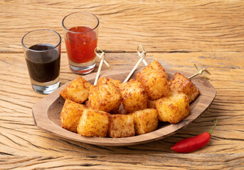 Tapioca dice, typical northeast brazilian food with chilli pepper and sugar syrup over wooden table