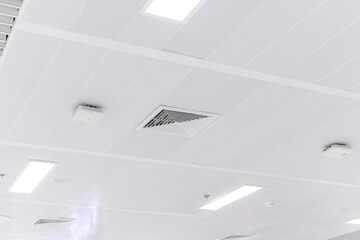 Ceiling mounted cassette type air conditioner and modern lamp light on white ceiling. duct air conditioner for home or office