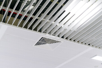Ceiling mounted cassette type air conditioner and modern lamp light on white ceiling. duct air conditioner for home or office