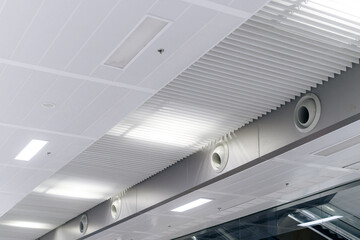 Ceiling mounted cassette type air conditioner and modern lamp light on white ceiling. duct air conditioner for home or office