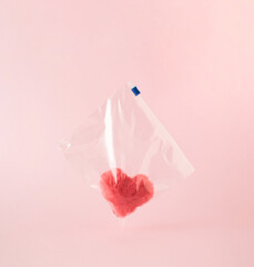 Pink fluffy plush heart in plastic zip bag.  Minimal love or Valentine concept.