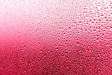 Background of drops on the glass in the glow of the sunset. Magenta background