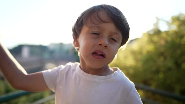 One little boy hitting own head with hand. Portrait of a child embarrassed by mistake standing outdoors. Oh no concept