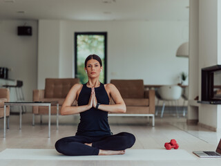 Young Beautiful Female Exercising, Stretching and Practising Yoga with Trainer via Video Call Conference in Bright Sunny House. Healthy Lifestyle, Wellbeing and Mindfulness Concept.