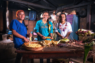 Retrato de Mujeres pelando y cortando elotes frescos para cocinar alimentos en una cocina antigua...