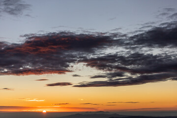 sunset at the top of the mountain with views of the clouds and the forest with a spectacular colors of sunlight