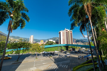 Fototapeta na wymiar Medellin, Antioquia, Colombia. January 13, 2022: Landscape with beautiful blue summer sky in main square and view of pedestrian bridge.