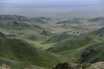 Far panoramic view of the mountains and the valley in the Malaysary gorge, mountain hills with rocky peaks covered with vegetation, spring, sunny