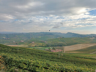 Fototapeta na wymiar two hot air balloons fly over the Barolo hills