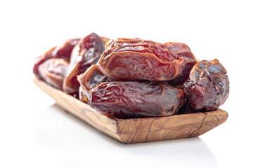 Dates in a wooden dish isolated on a white background.