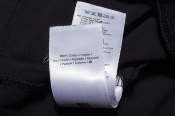 100 cotton tag in various languages on black jumper