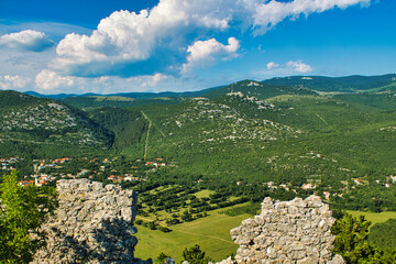 view through a hole in an ancient wall on a mountain