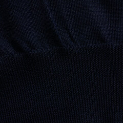 Knitted elastic band on navy wool sweater close up