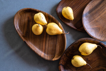 Handmade walnut round wooden pallet, wooden chopping board Empty pear gray background  bowl with wood rings Handmade plank texture Tableware dark brown old tray cooking serving.