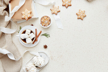 Christmas aesthetic seasonal background with cup of hot drink, white marshmallows, homemade snowflakes cookies, cinnamon sticks and books at cozy home. Copy space