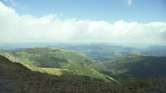 Panorama of mountains in sunny weather in the Carpathians. Average cloud cover on top of the mountain. Beautiful horizon, distant mountains. High quality 4k footage
