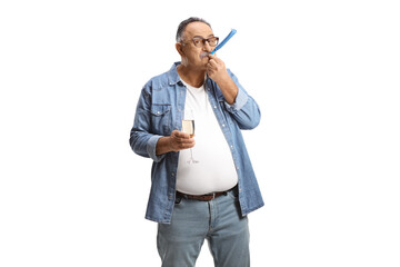 Mature man blowing a party horn and holding a glass of champagne