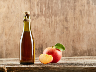 Apple vinegar cider with apple fruits on old wooden background. Fermented product
