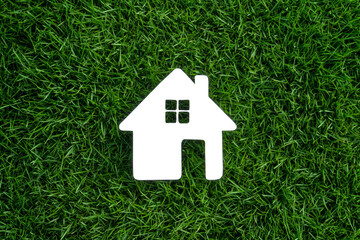 Close-up of a white paper house shape on the lawn.