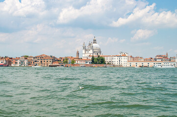 View of the Venice Canal embankment on a warm summer day, with floating boats and old houses, Venice, Italy