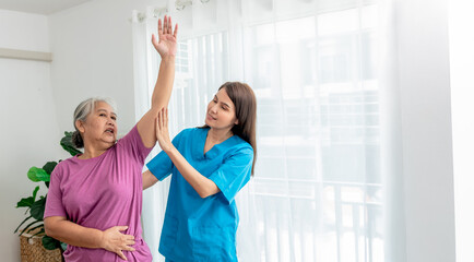 Physical therapist Asian woman, doing arm physiotherapy for elderly woman, to treat osteoarthritis...
