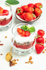 strawberry parfaits with fresh fruit, yogurt and granola, vertical image. top view. place for text