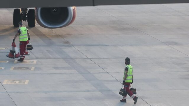Larnaca, Cyprus. May 15, 2021: The airport staff is engaged in the reception and maintenance of a passenger aircraft, placing fencing cones
