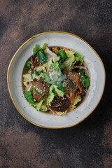 Chinese fried shiitake mushrooms, close-up in a plate on dark background