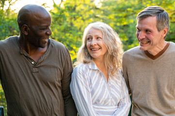 Fototapeta premium Three middle-aged friends hanging out together ourdoors