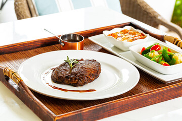 Beef steak,Modern style barbecue dry aged sliced roast beef with fried onion rings and mashed potatoes as closeup on a plate