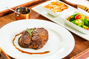 Beef steak,Modern style barbecue dry aged sliced roast beef with fried onion rings and mashed potatoes as closeup on a plate