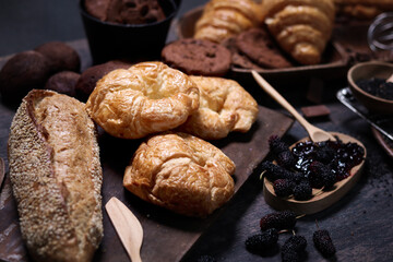 Sweet pastries, fresh baked butter breakfast croissants with sourdough and Danish pastry, puff pastry, breads and many desserts on wood table, delicious homemade bakery concept