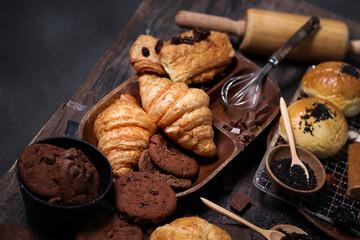 Sweet pastries, fresh baked butter breakfast croissants with sourdough and Danish pastry, puff pastry, breads and many desserts on wood table, delicious homemade bakery concept