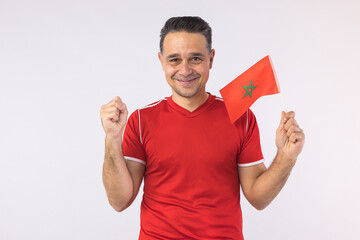 Man wearing a red shirt, holding a Moroccan flag. Sport, world cup.