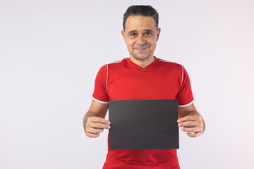 Man wearing a red Moroccan shirt, holding a black sign. Sport, world cup.