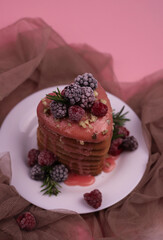 sweet fragrant lush pink heart-shaped pancakes with pink delicious icing on top and decorated with raspberries and blackberries with green rosemary sprigs. for signage, menu labels, and more