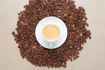 xícara com café em cima de cafe em grão