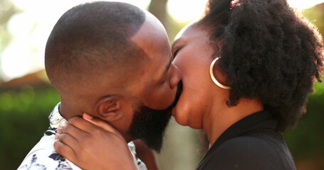 African couple in love kissing outside wiht lens-flare