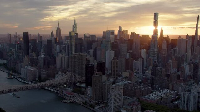 Aerial Shot of Upper East Side  Skyline in Manhattan, New York City. Amazing Cloudy Sky at Sunset. Famous Queensboro Bridge. High Quality Footage Shot from Helicopter over East River. United States