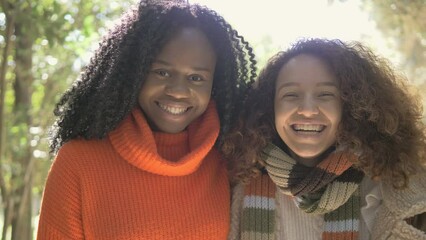 happiness, joy - black girl and hispanic girl laughing looking at the camera