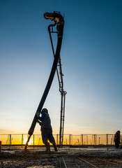 Trabalhadores da construção civil, construindo um prédio, com estrutura de concreto e aço. 