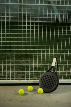 paddle tennis racket and balls on court, night image
