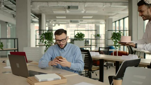 Surprise. Mixed race happy people celebrating a birthday of colleague in the modern office
