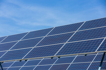 Solar cells panels. Solar farm on blue sky background. Photovoltaics solar cells panels in solar power station. Green energy from natural and Clean energy concept